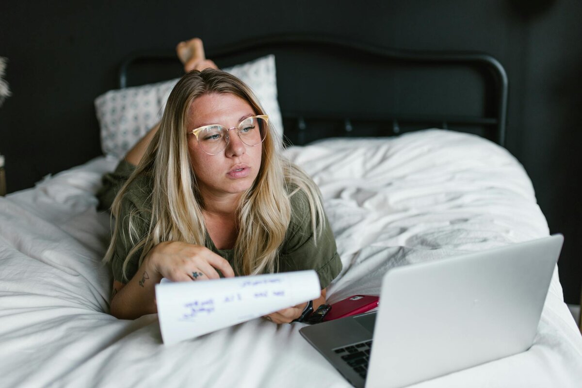 Lady laying on her bed with paper