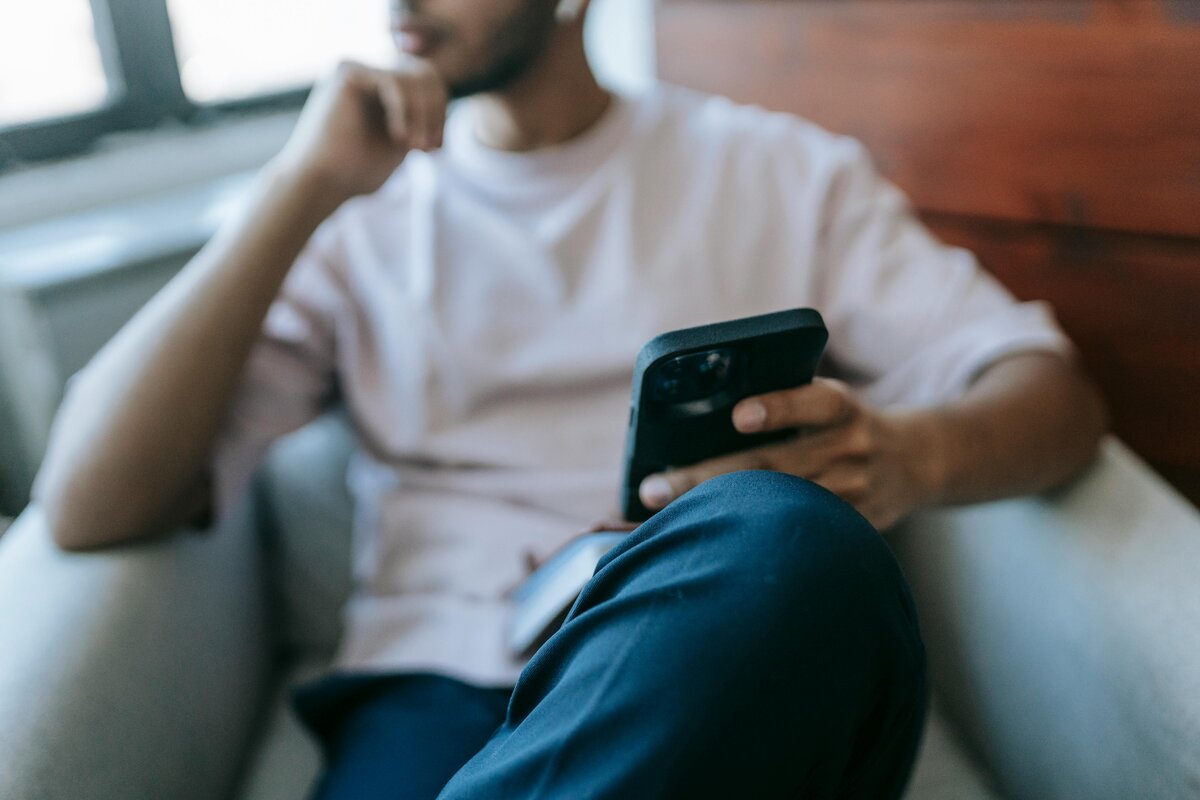 man sitting and using his phone