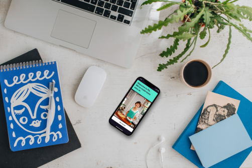 Freelancer workspace with laptop, notebook and phone showing tax app