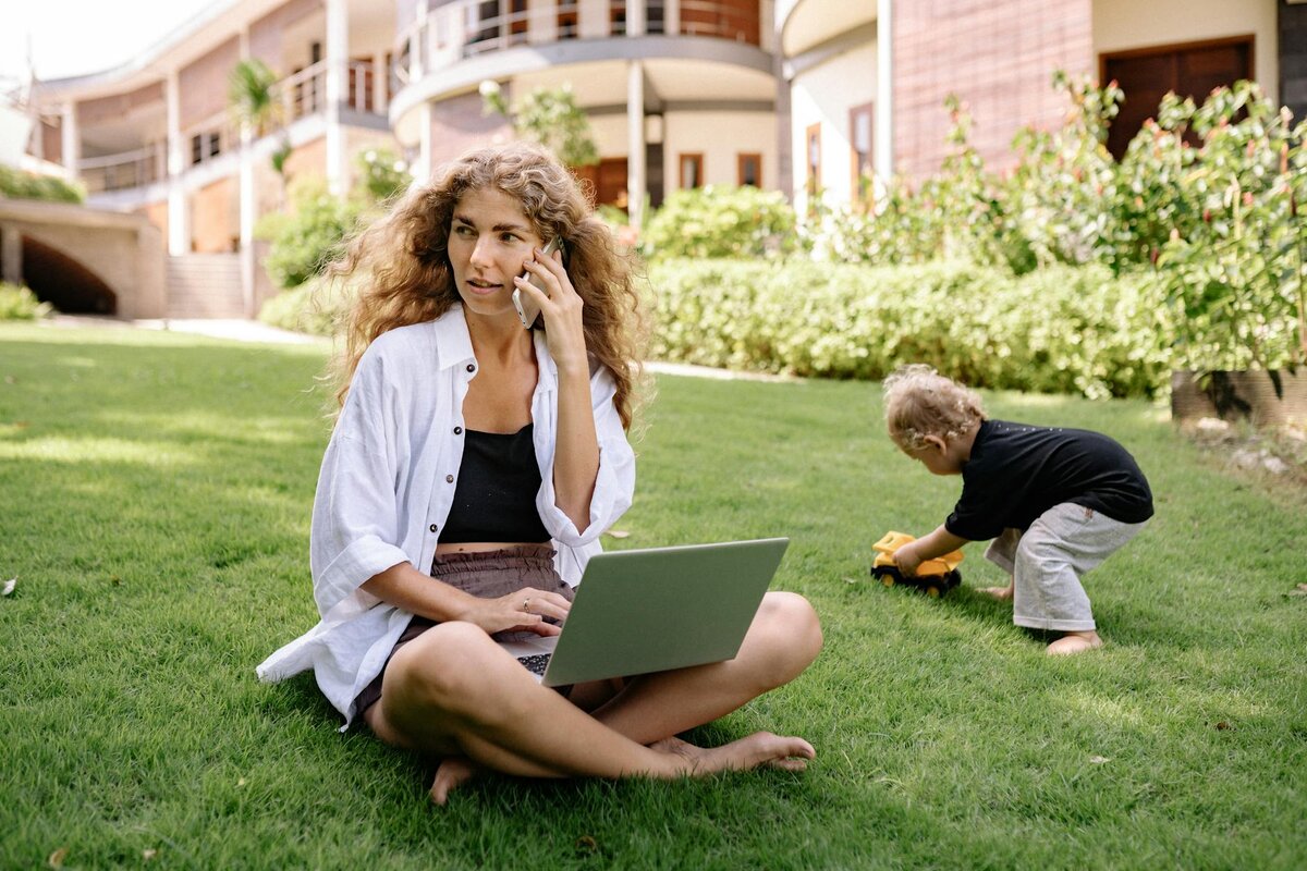 lady on laptop with kid behind 