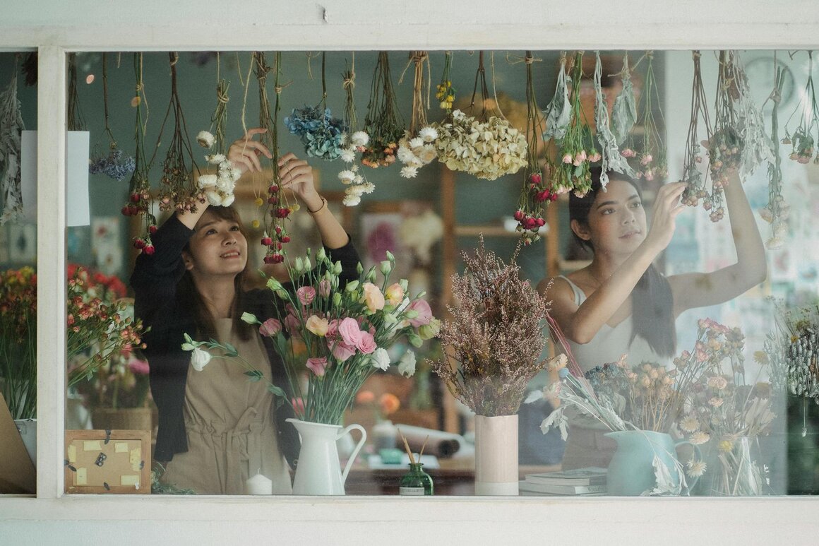 ladys fixing flowers in the window 
