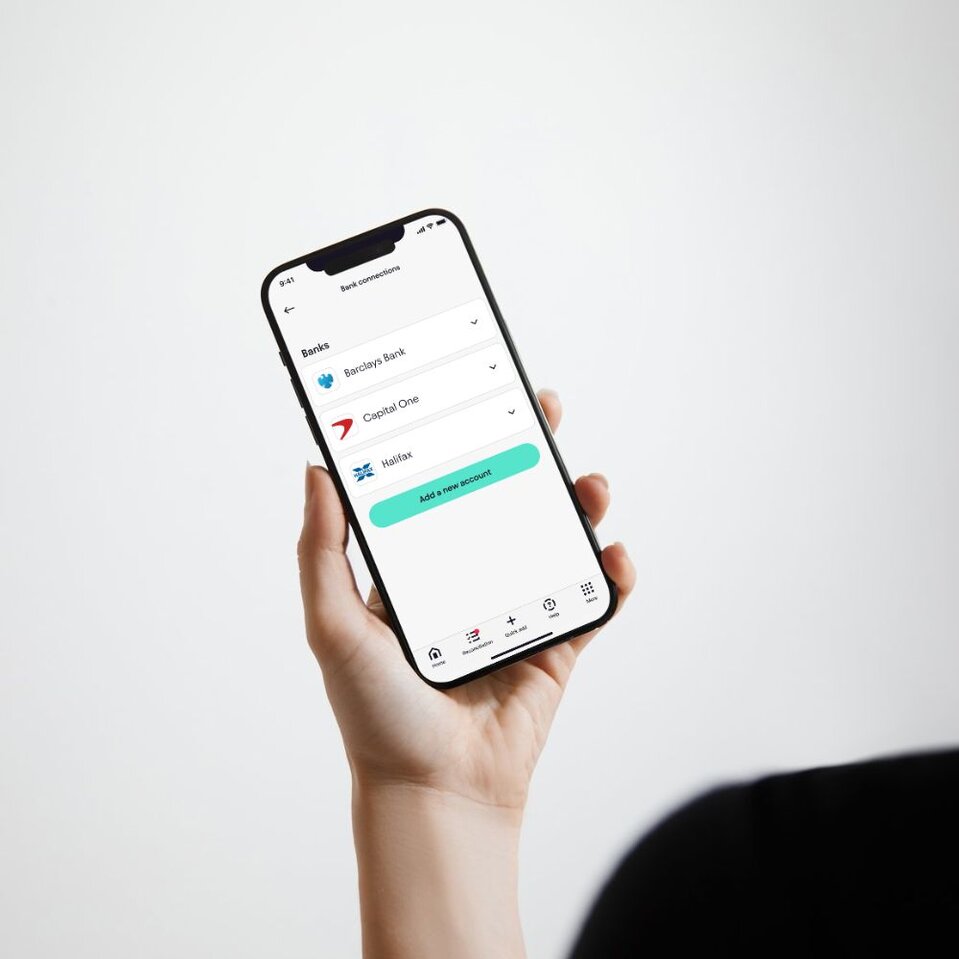 Hand holding smartphone displaying mobile banking app screen