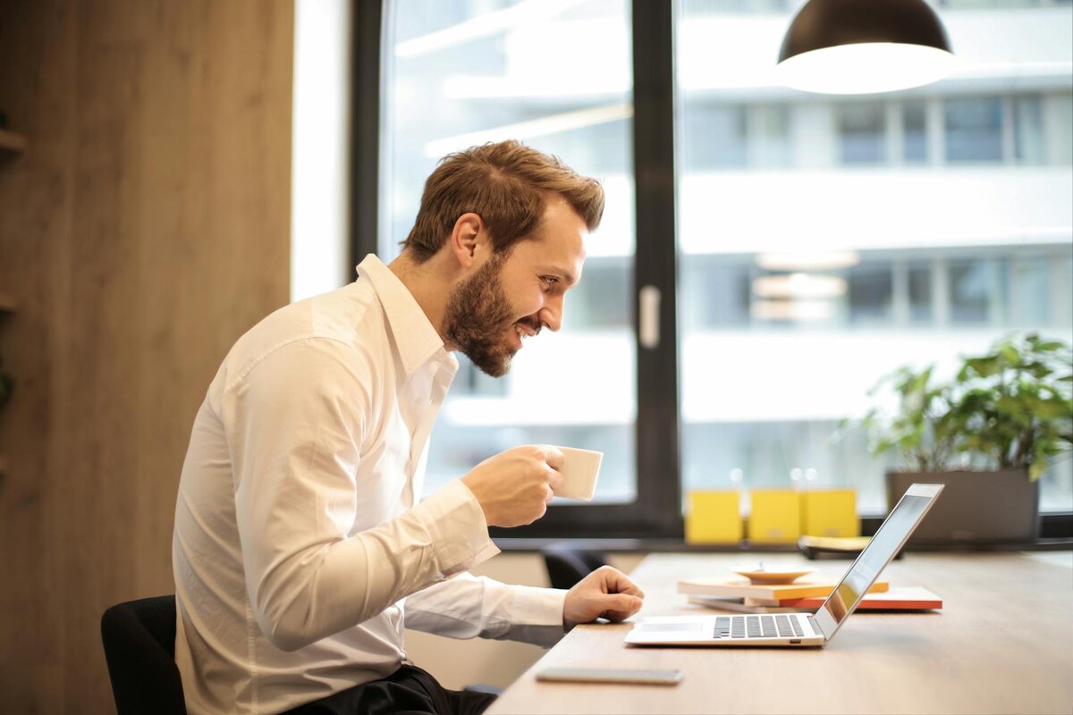 Man on laptop with cup of tea
