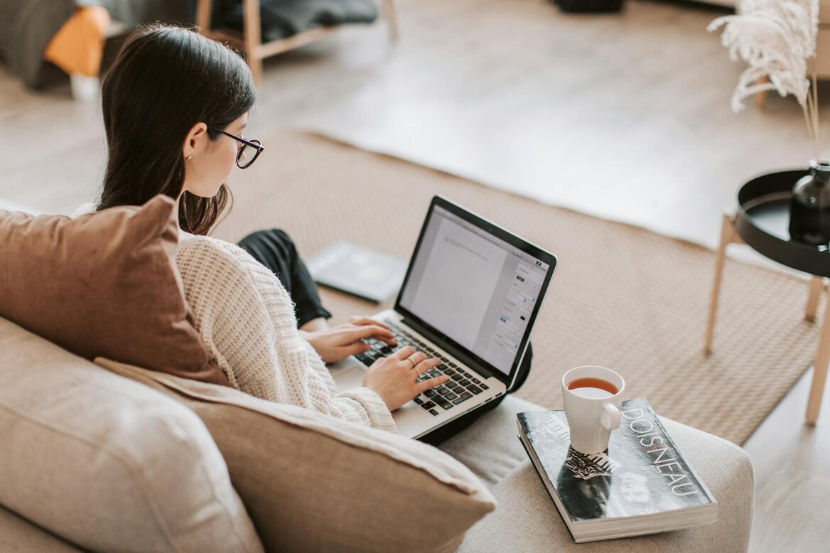 Woman focused in her laptop searching for UK tax guide for network marketers