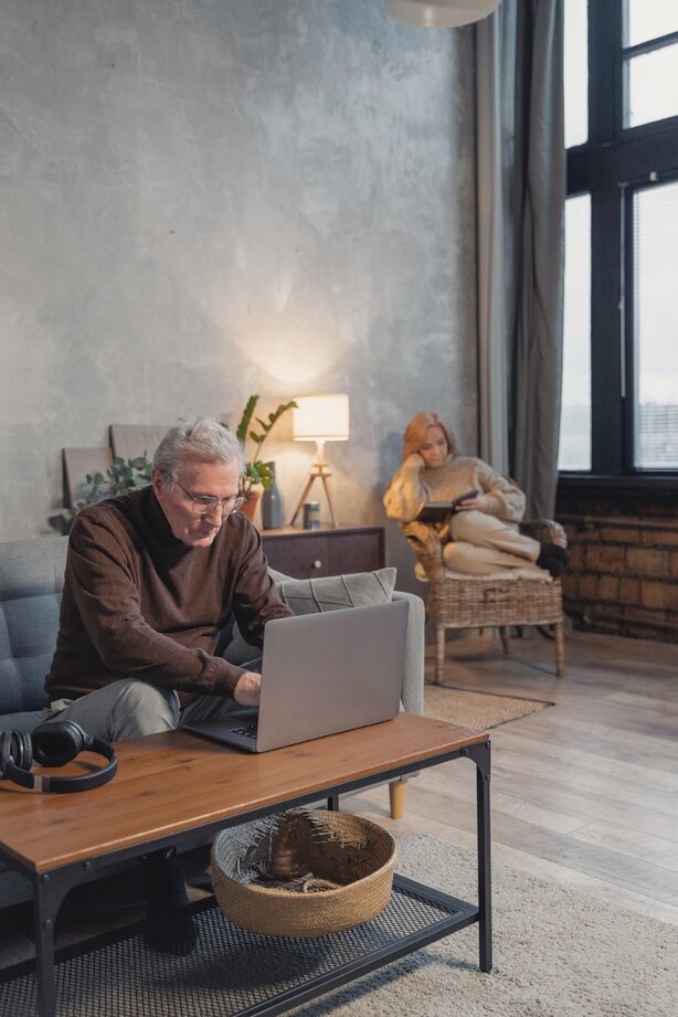 Man using laptop with his wife