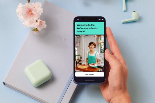 Hand holding a phone displaying the Pie app's welcome screen.