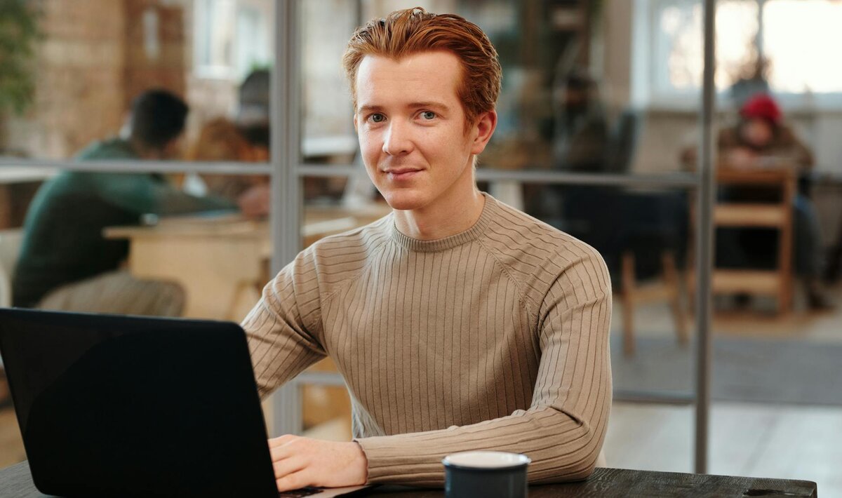 man smiling while on his laptop