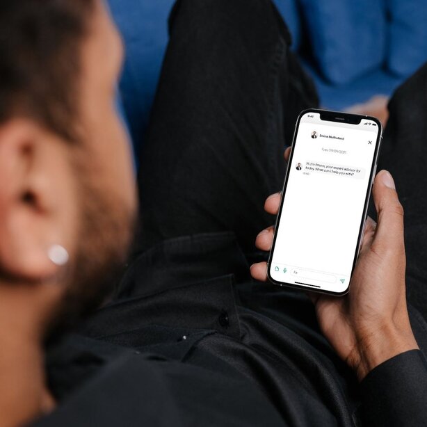 Man holding smartphone viewing app while sitting relaxed