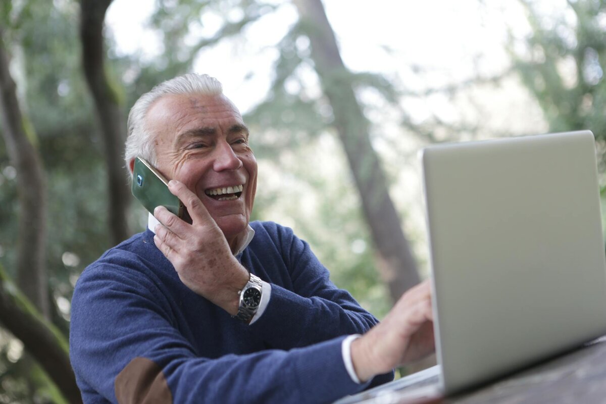 A businessman looks happy working outdoors with laptop