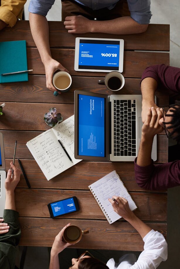 people sitting at a table looking at a laptop