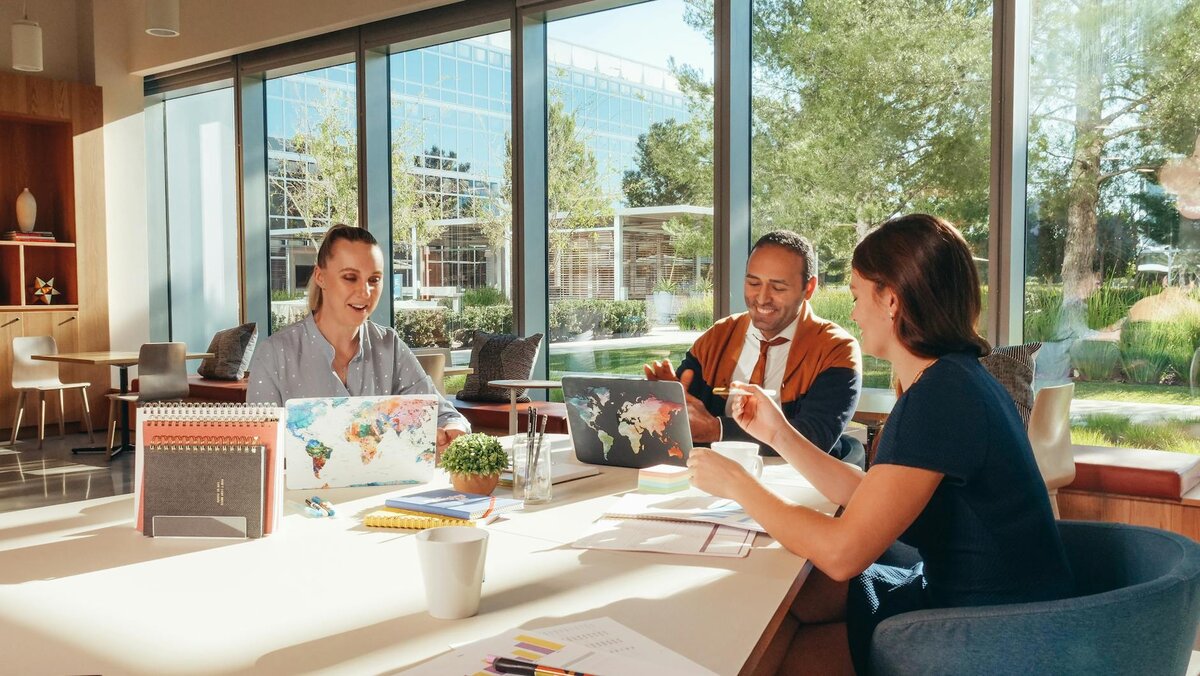 Two women and a man working together in a office 