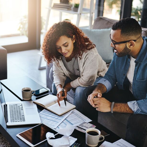 Couple reviewing financial documents together at home table
