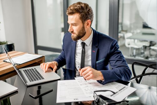 Young businessman working in office on laptop 