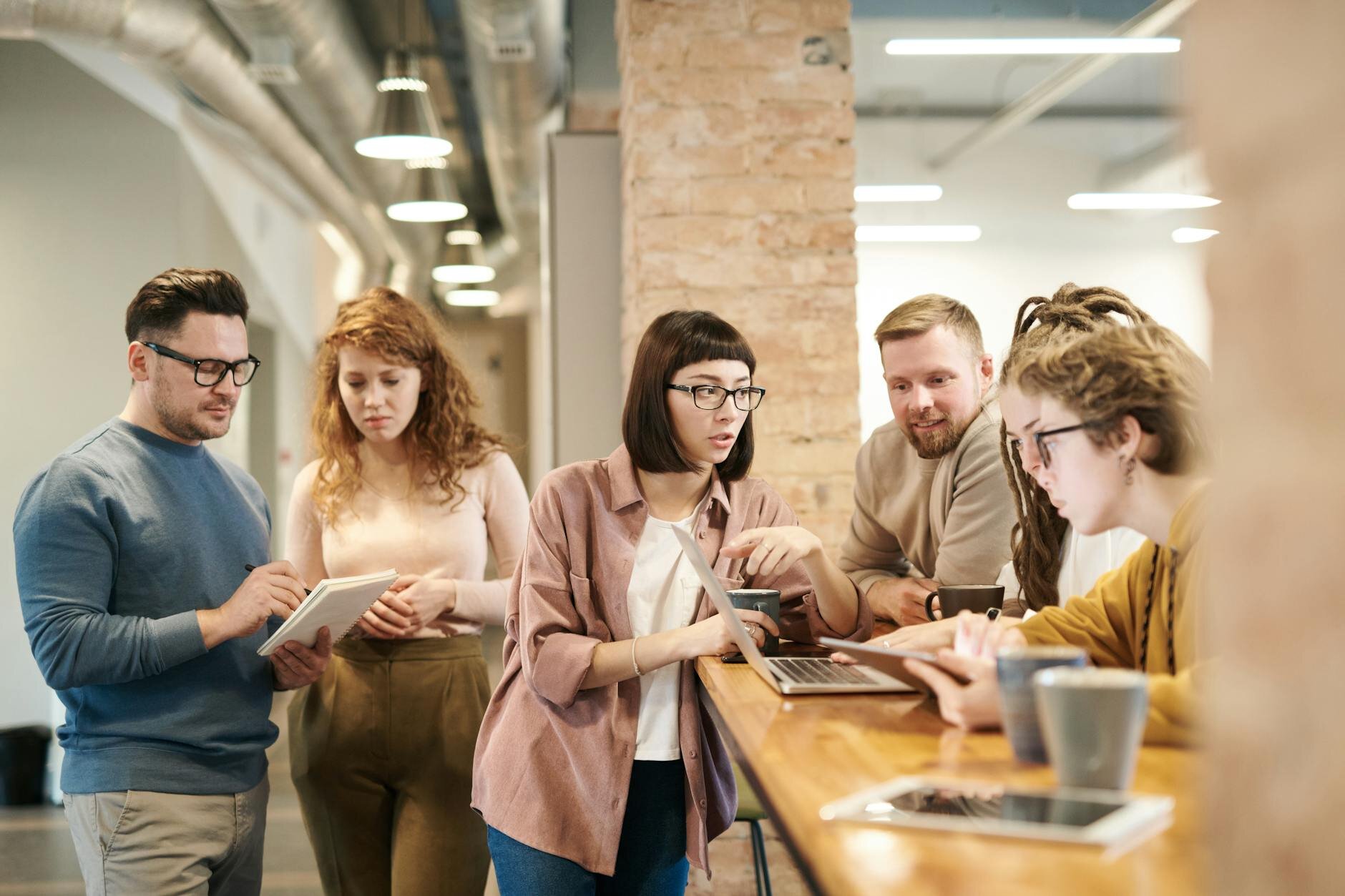 a group of work colleagues working together drinking coffee. 