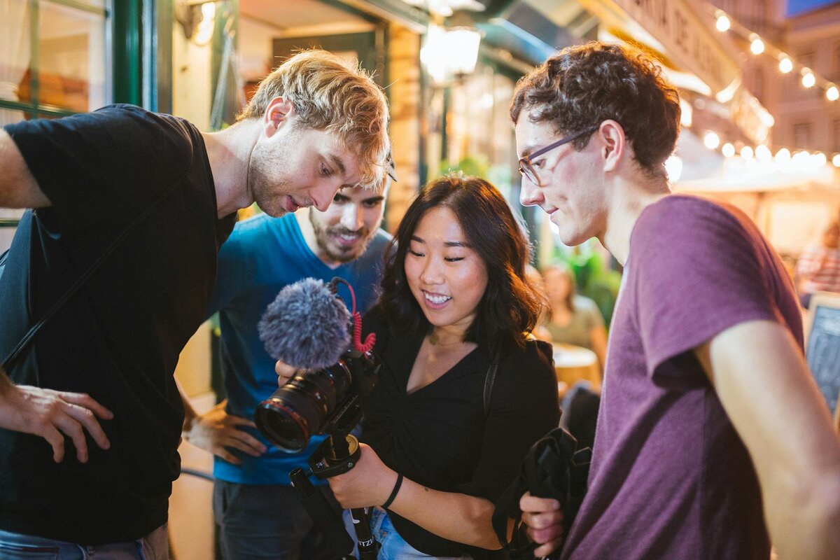 multiple people looking at some filming that was complwted on a camera 