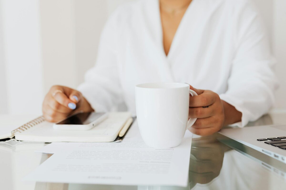 Woman at her desk with a cup of coffee together with the monthly report document