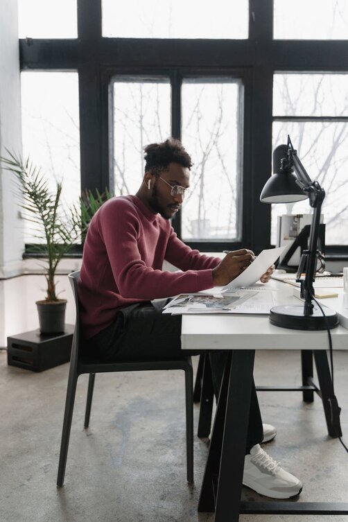 Small business owner reviewing paperwork and business expenses at a desk