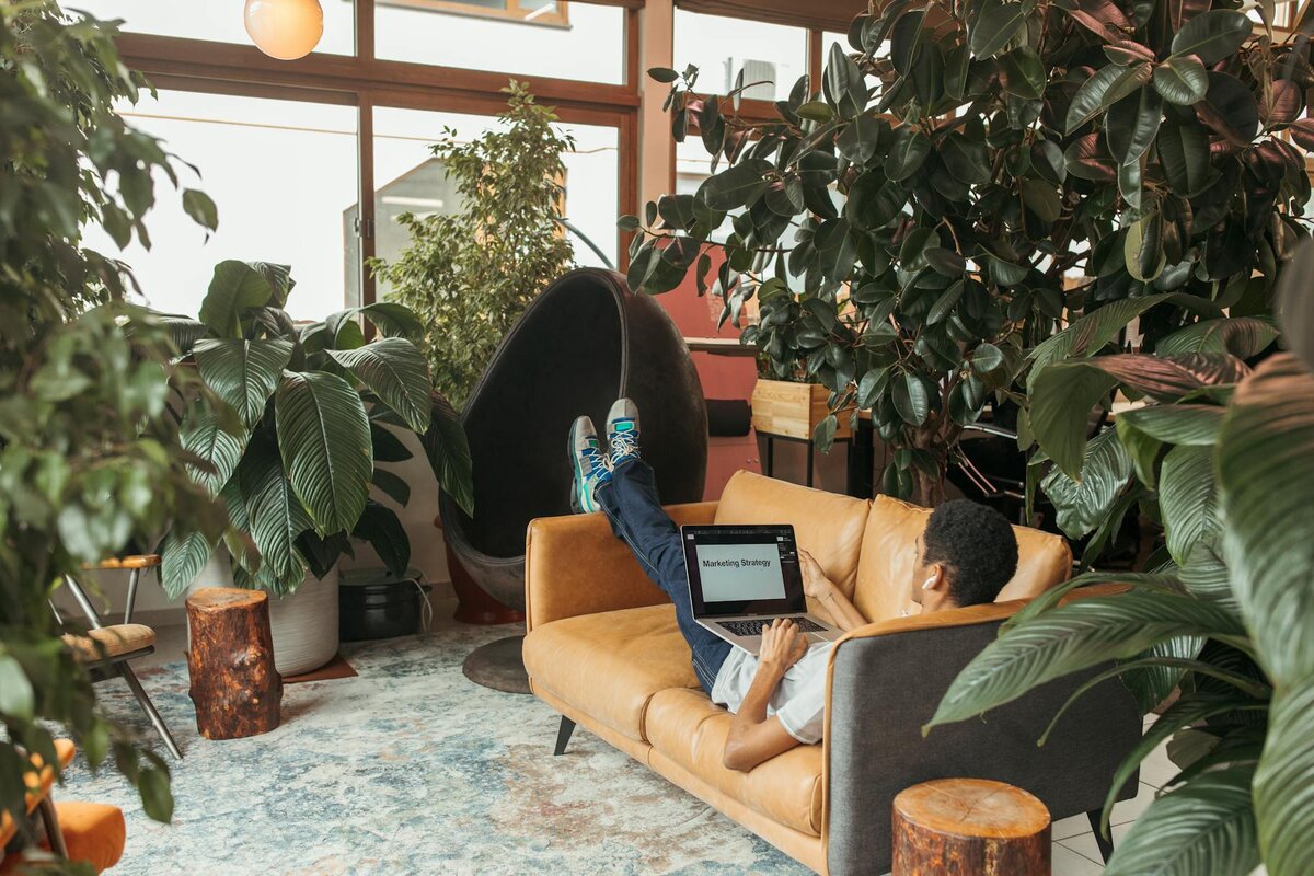 man lounging on couch with his laptop 