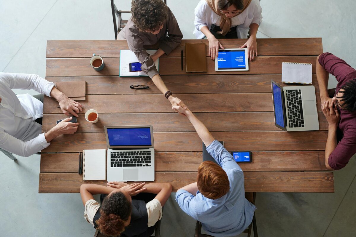 A group of people stitting round a table working 