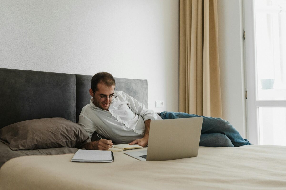 Man working on laptop at his bed