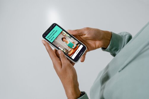 Person holding smartphone browsing colorful mobile app screen