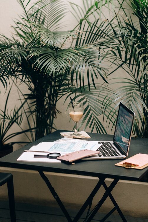 table with laptop and papers around it