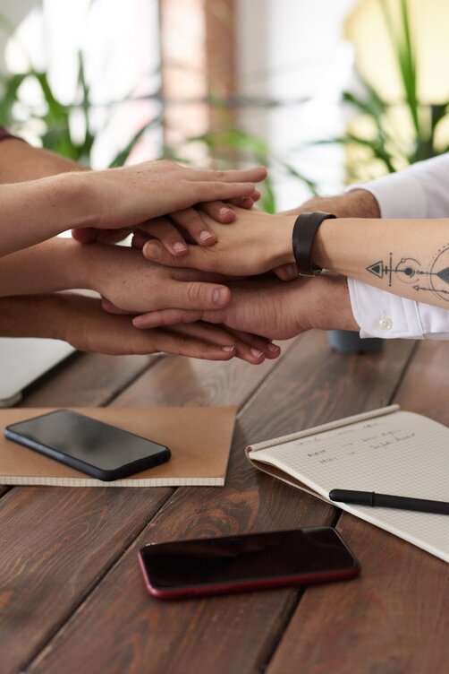 Group of hands stacked together in team gesture