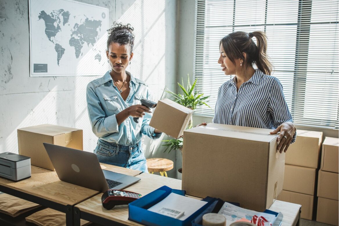 Small business owners packing orders and managing inventory in a workspace