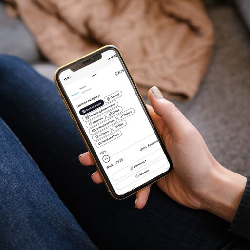 Hand holding smartphone displaying financial app interface clearly