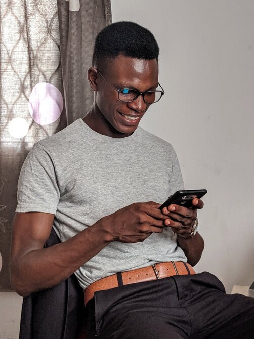 Man holding smartphone while sitting relaxed