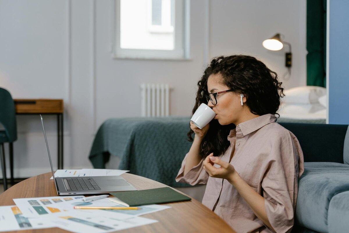 Lady on floor with her laptop and cup of coffee