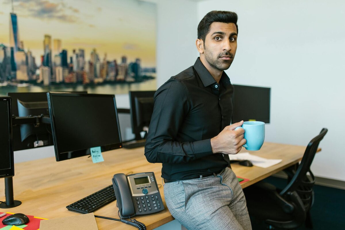 Man holding a cup of coffee after knowing about the Tax Guide