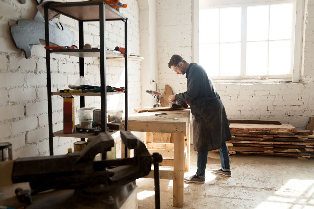 Man working on woodworking project in bright workshop