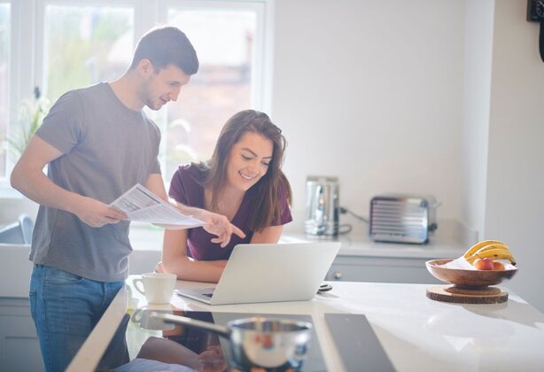 Man pointing at the laptop while the woman is using the laptop