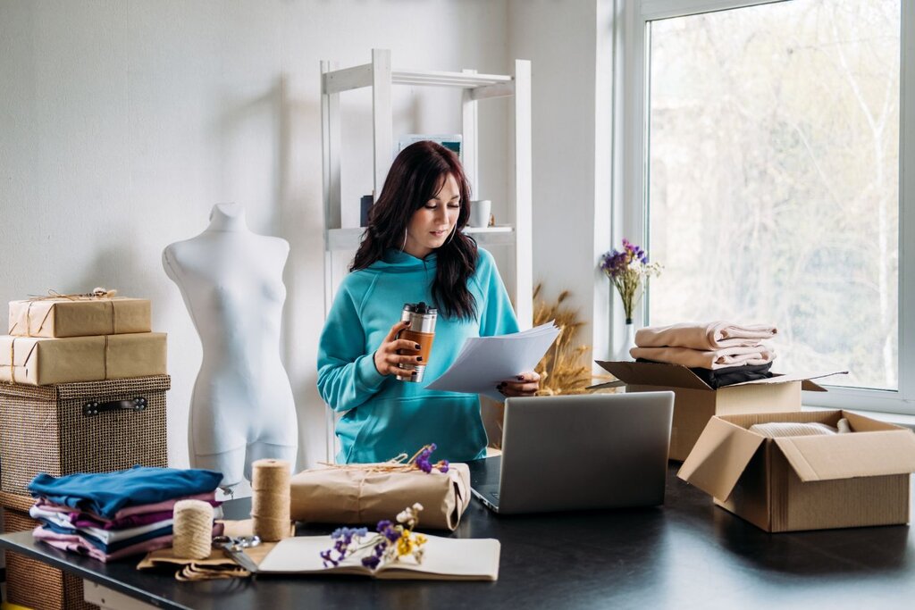 Woman reviewing documents in bright fashion studio workspace