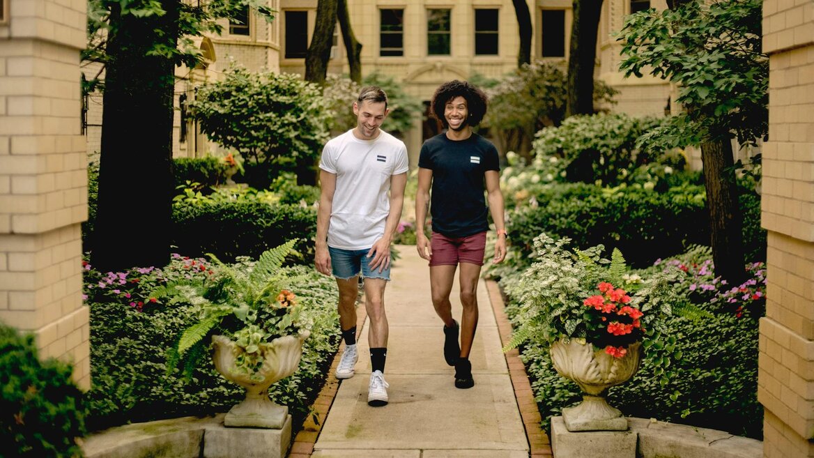 Two UK taxpayers walking outdoors in a residential garden area