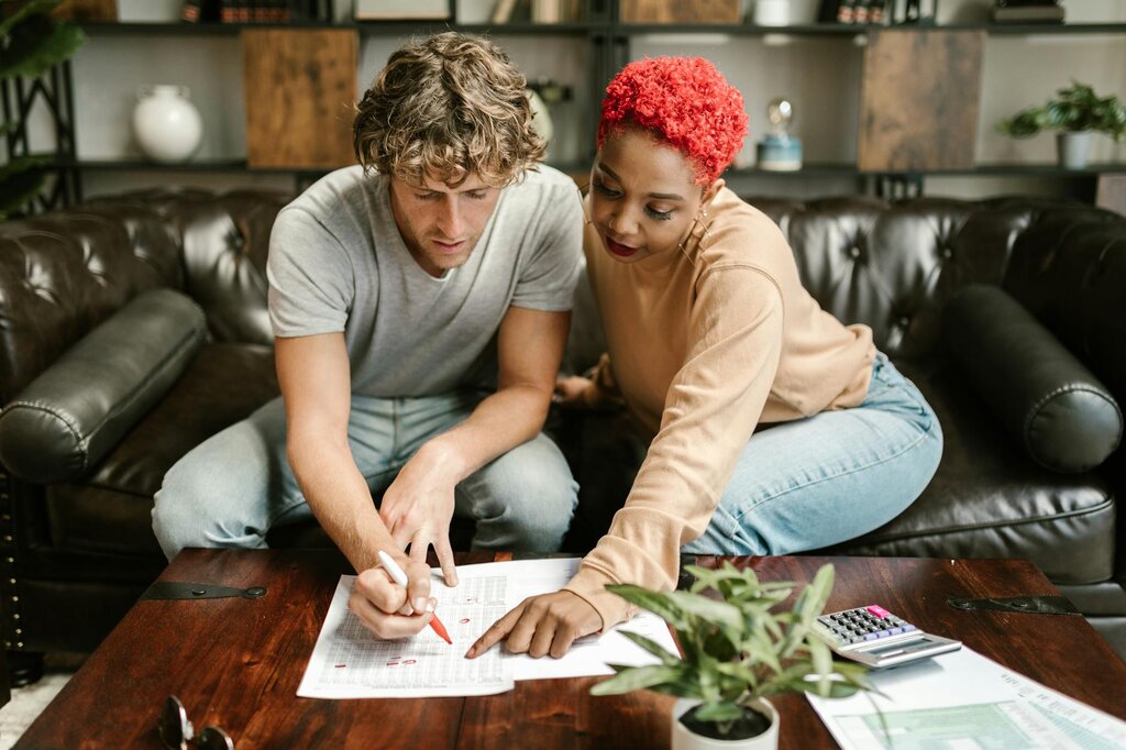 Couple reviewing paperwork and calculating household finances together.