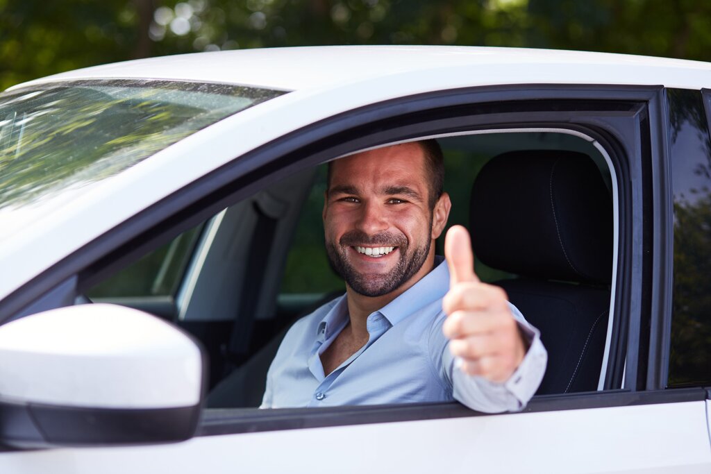 man thumbs up in a white car