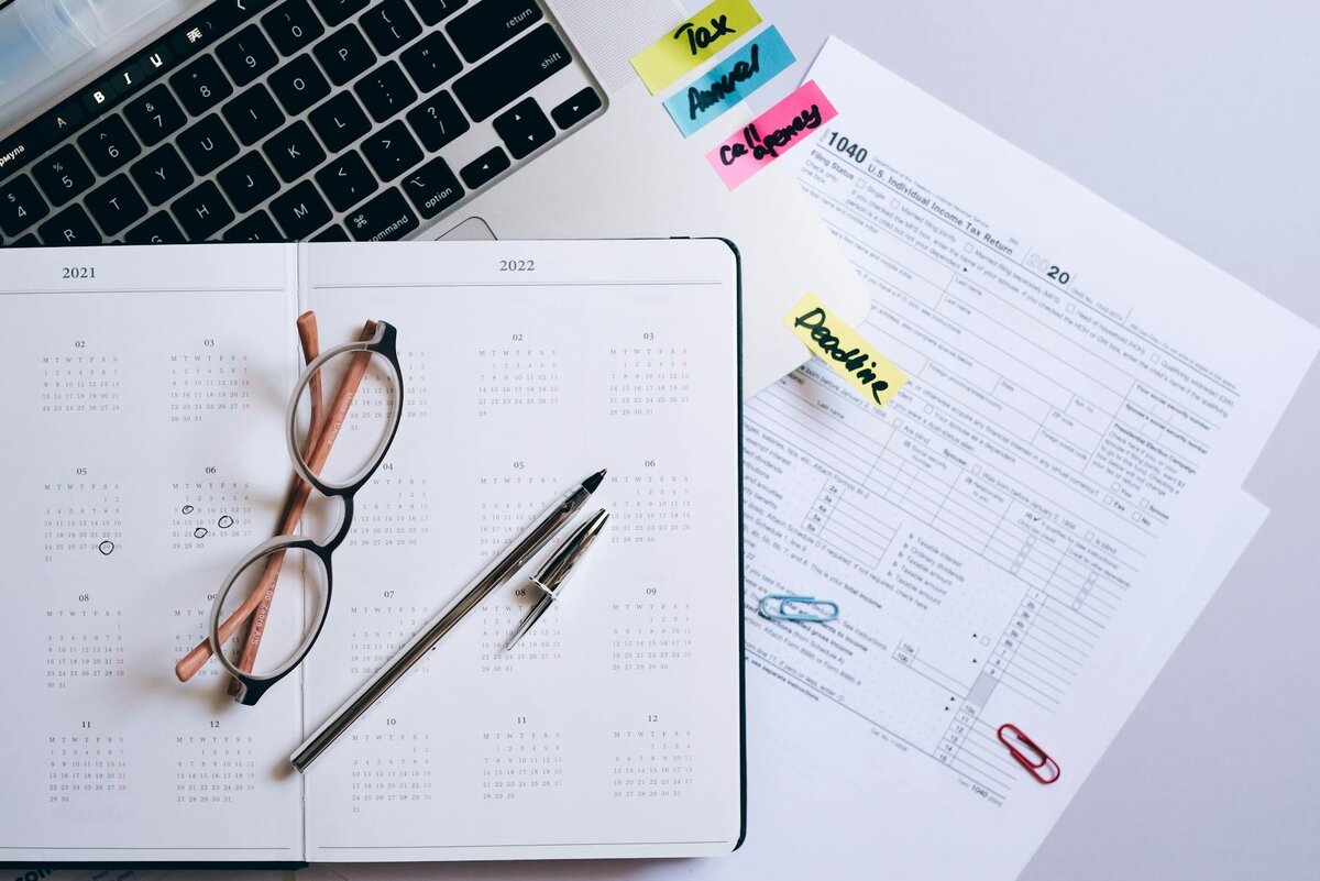 a notebook calendar with pen and glasses